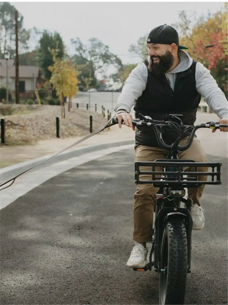 Electric cargo bike with fat tires and a front cargo rack.